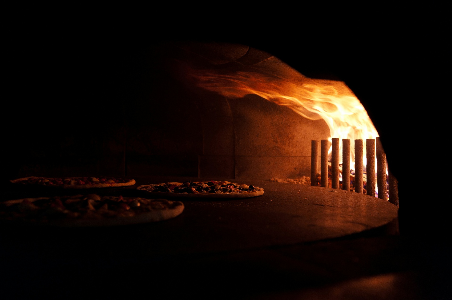 Multiple pizzas inside wood-fired dome oven