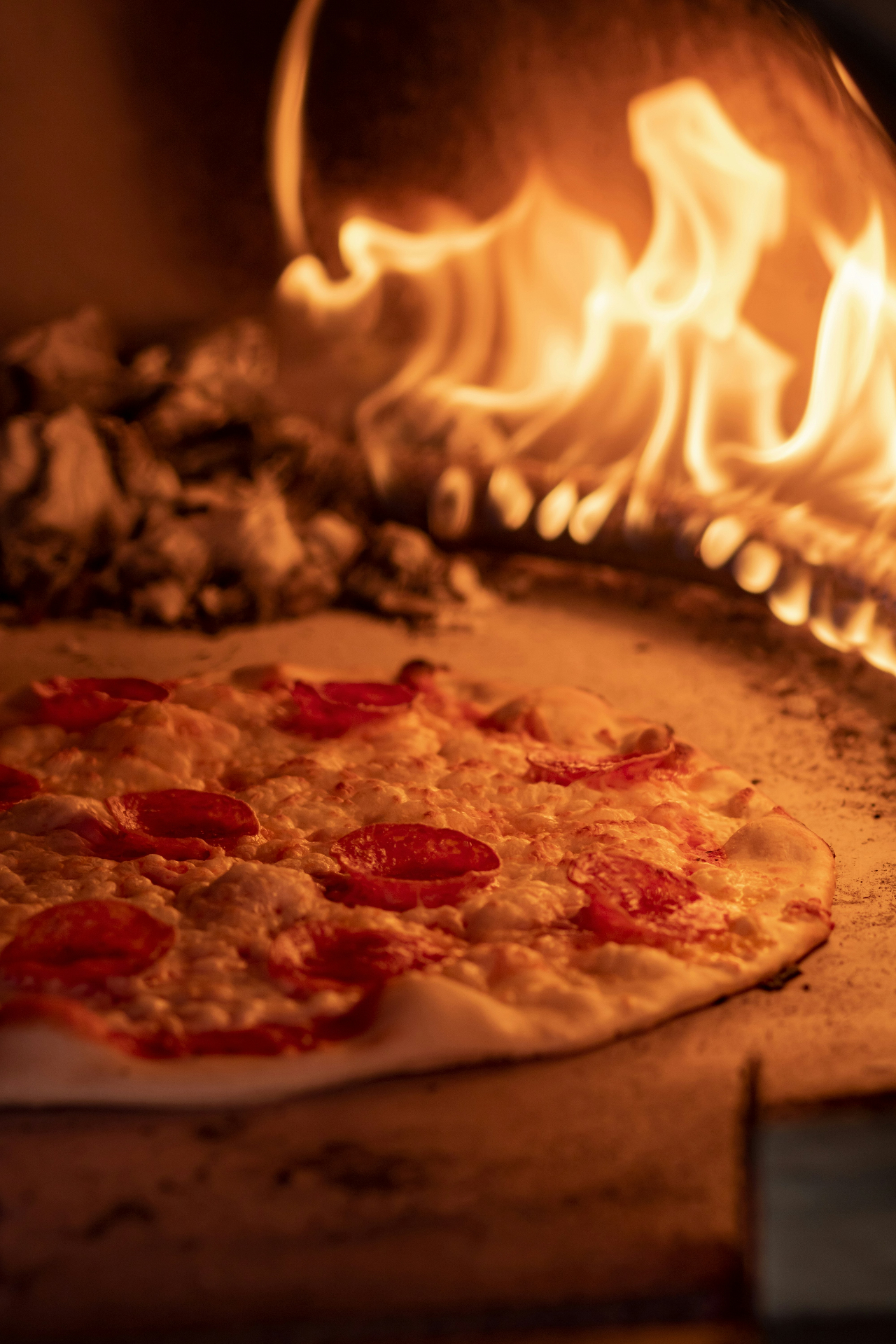 Pepperoni pizza inside wood-fired oven
