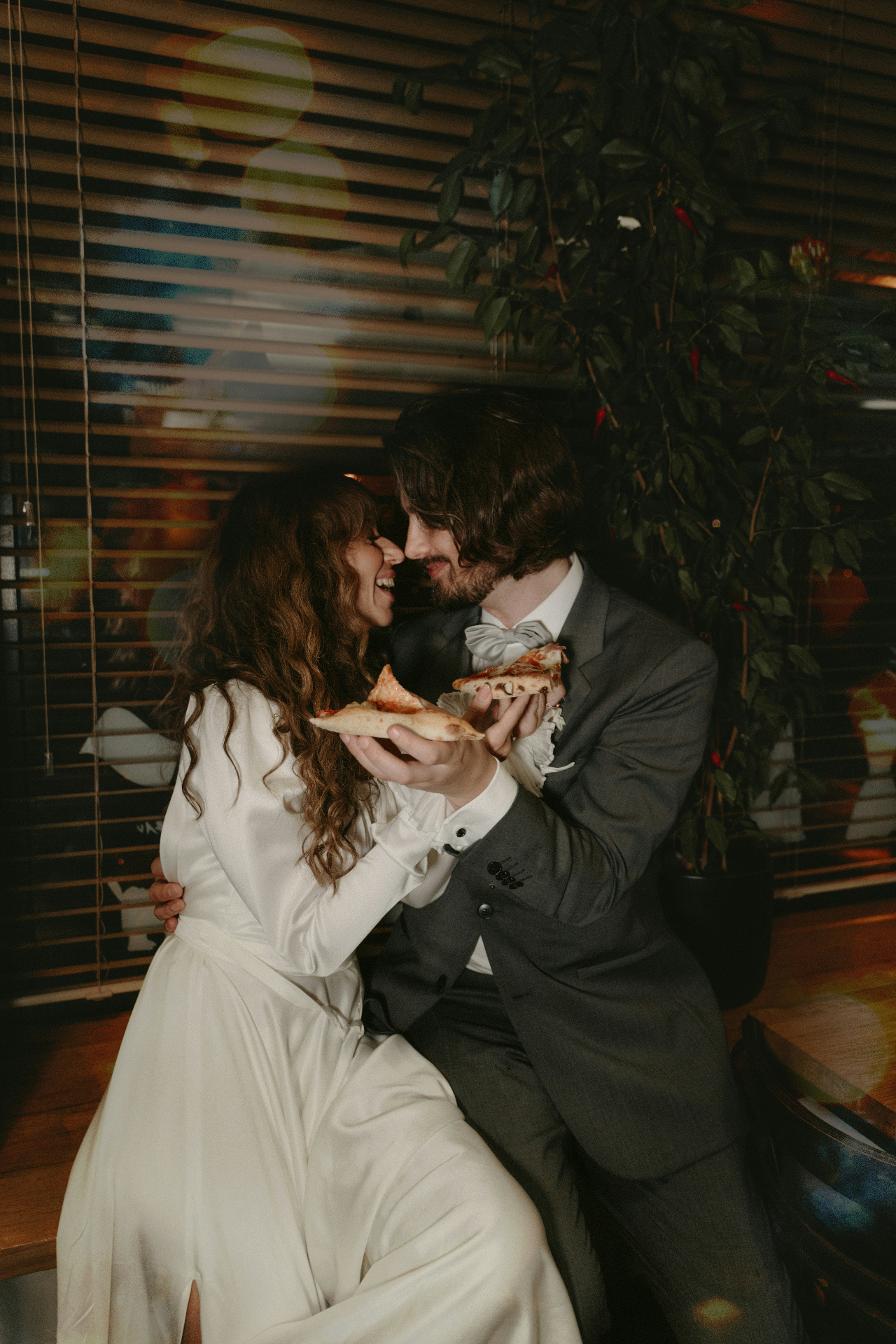Bride and groom sharing a slice indoors